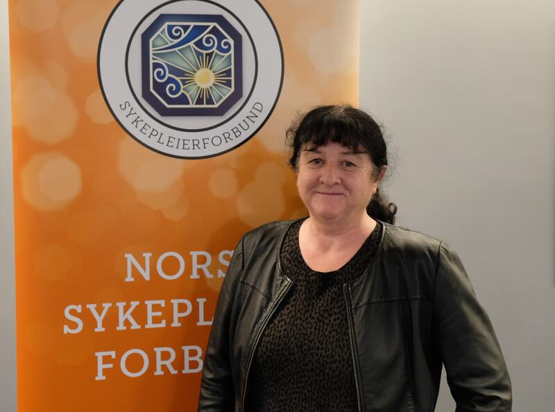 Profilbilde av Nina Budal, stående fremfor NSF logo